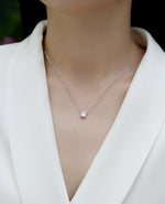 Load image into Gallery viewer, Éclat Cube Moissanite Necklace worn by a person in a white blazer.