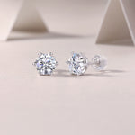 Load image into Gallery viewer, A pair of sterling silver stud earrings with round-cut moissanite stones, displayed against a neutral background.
