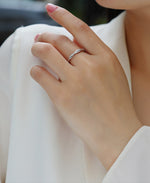Load image into Gallery viewer, Close-up of a hand wearing Élégance Twistée Moissanite Band
