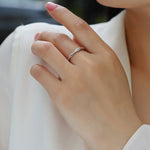 Load image into Gallery viewer, Close-up of a hand wearing Élégance Twistée Moissanite Band