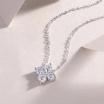 Load image into Gallery viewer, A silver necklace featuring a flower-shaped pendant with round-cut moissanite stones, displayed on a neutral background.