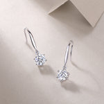 Load image into Gallery viewer, A pair of silver hoop earrings with round-cut moissanite stones, displayed against a beige background.