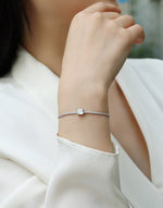 Load image into Gallery viewer, Close-up of a person wearing a Stellaire Cube Moissanite Bracelet