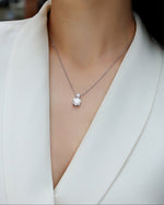 Load image into Gallery viewer, Double Éclat Moissanite Necklace worn by a model in a white blazer.
