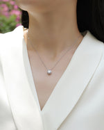 Load image into Gallery viewer, Éclat Bezel Moissanite Necklace on a model.
