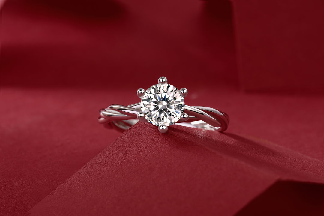 Éclat Entrelacé Moissanite Ring on a red fabric background