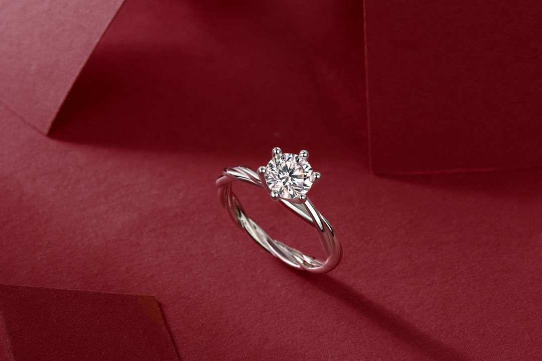 Éclat Entrelacé Moissanite Ring on a red fabric background