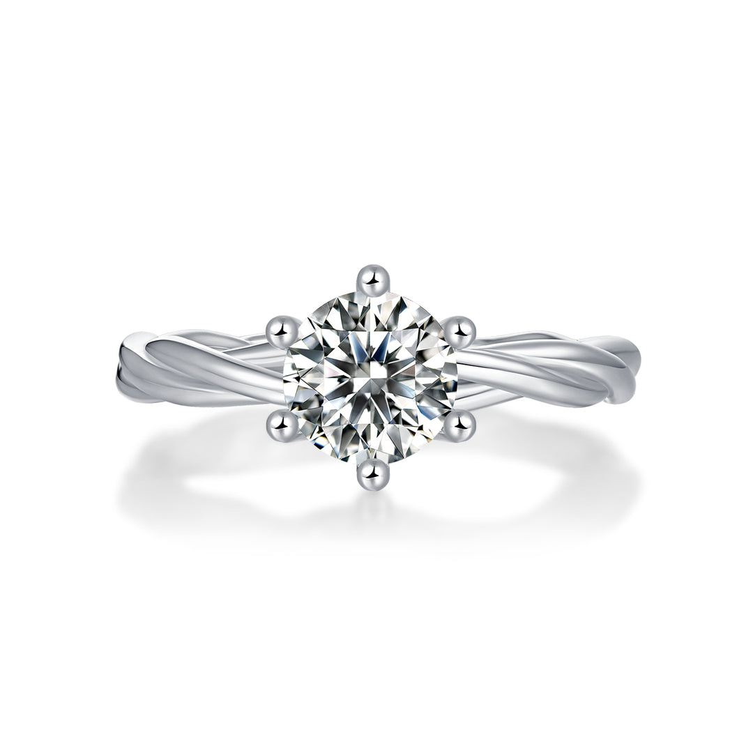 A round-cut moissanite ring with a twisted band design, set in a platinum band.