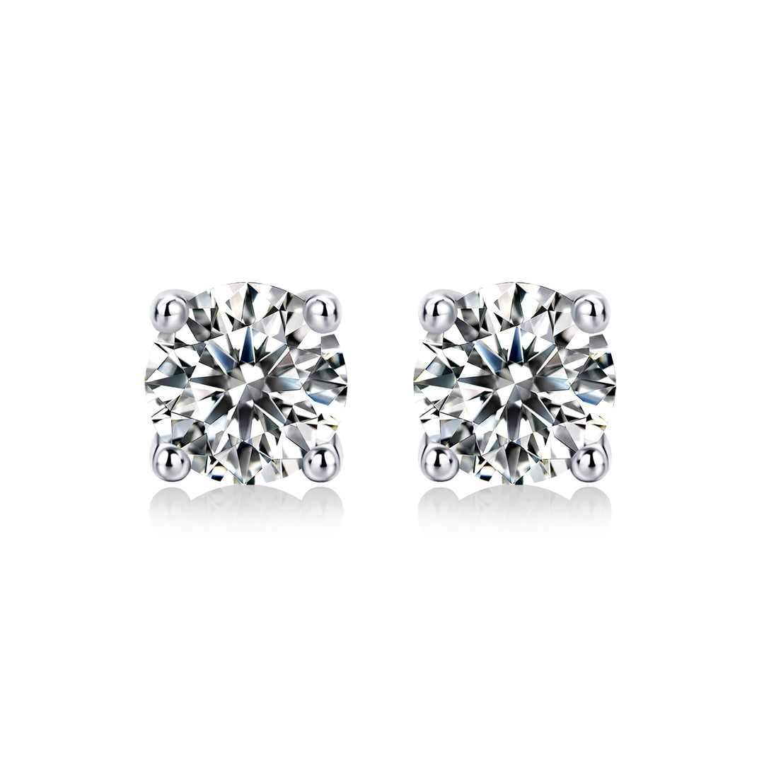 A pair of round-cut moissanite stud earrings held in a four-prong setting, on a white background.
