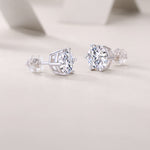 Load image into Gallery viewer, A pair of round-cut moissanite stud earrings with a classic six-prong setting on a white background.
