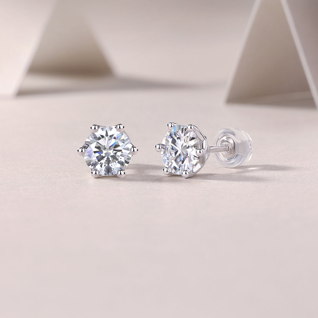 A pair of sterling silver stud earrings with round-cut moissanite stones, displayed against a neutral background.