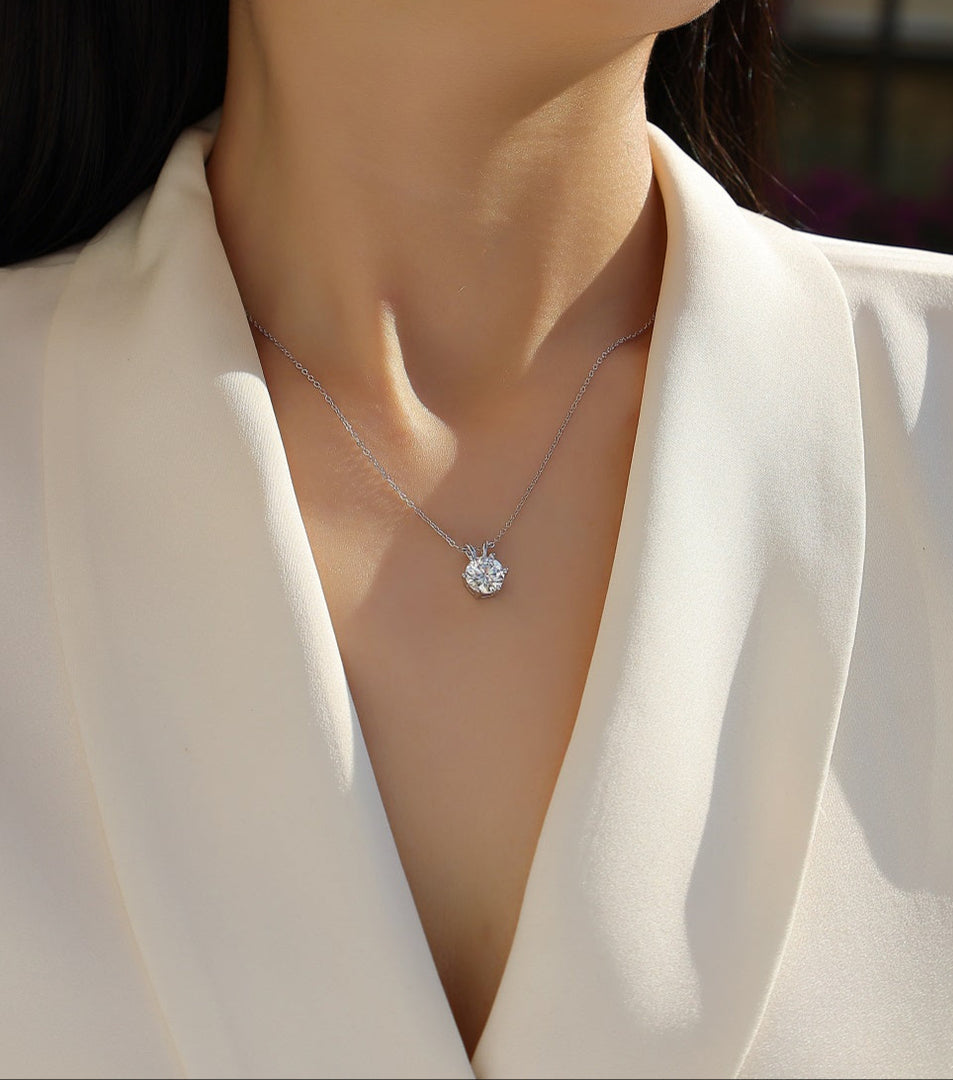 Éclat Solitaire Moissanite Necklace worn by a model in a white blazer.