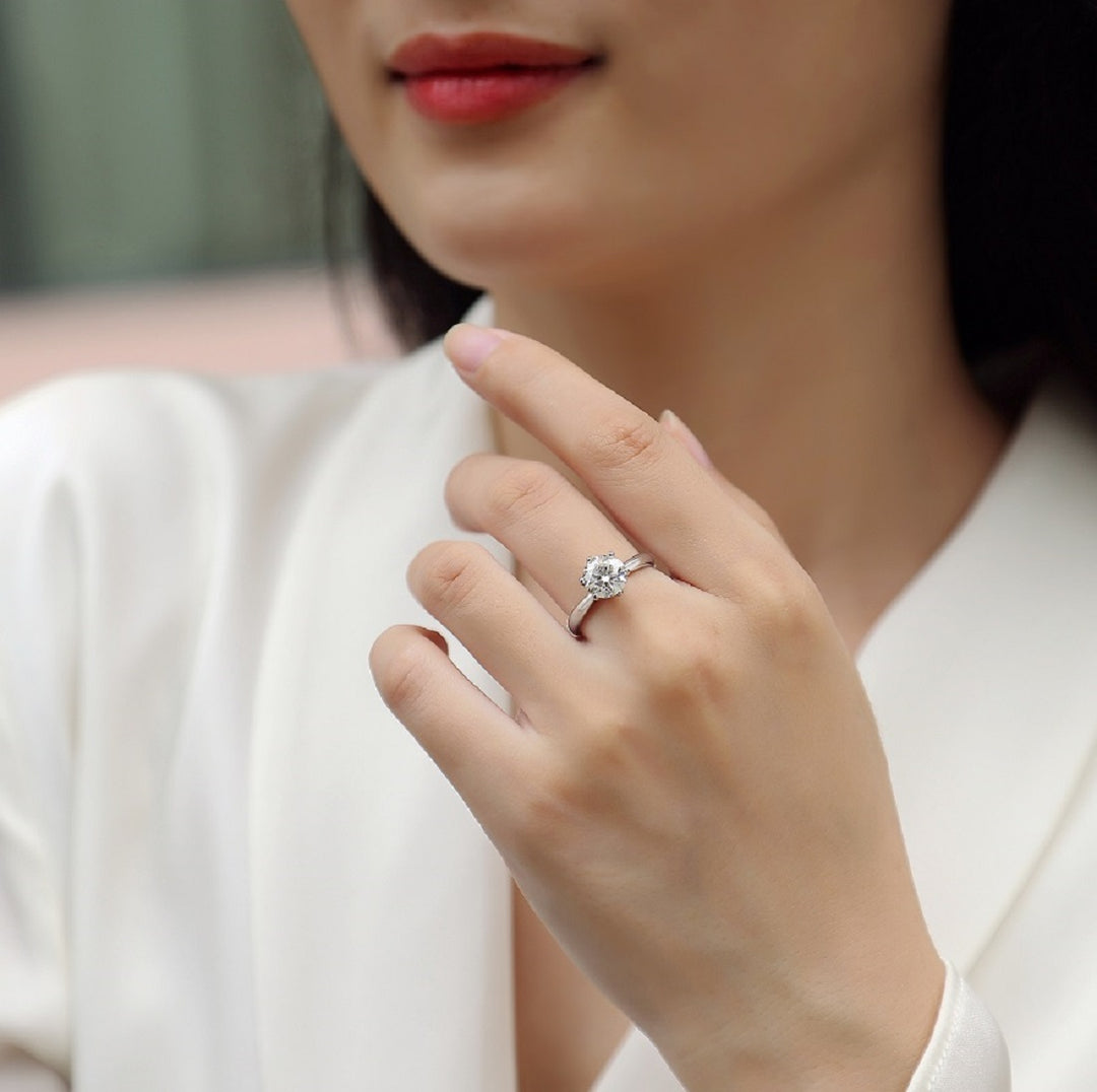 Close-up of a hand wearing Éclat Solitaire Moissanite Ring