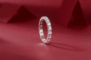 Éternelle Majesté Moissanite Band on a red fabric background