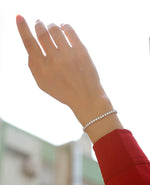 Load image into Gallery viewer, Hand wearing a moissanite tennis bracelet
