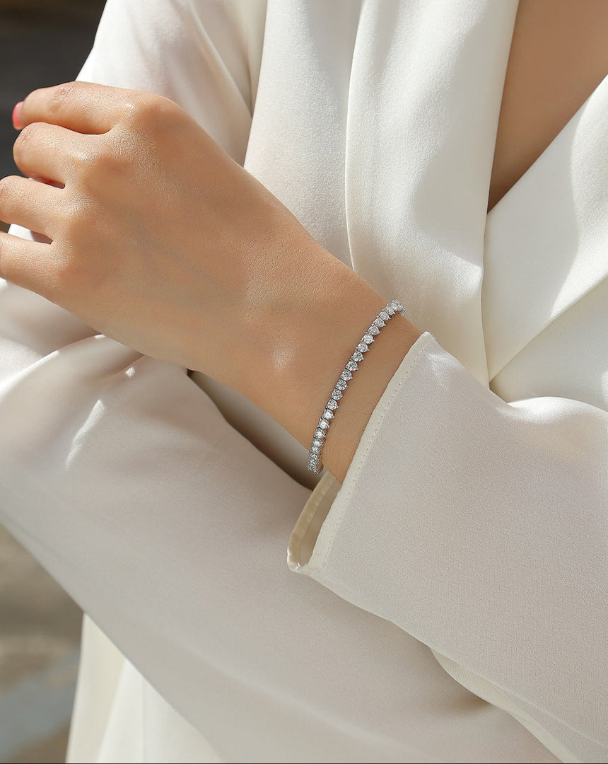Close-up of a person wearing Eternelle Princesse Moissanite Tennis Bracelet on a white outfit