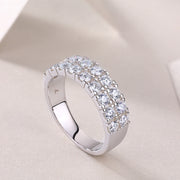 A silver band ring with two rows of round-cut moissanite stones set on it.