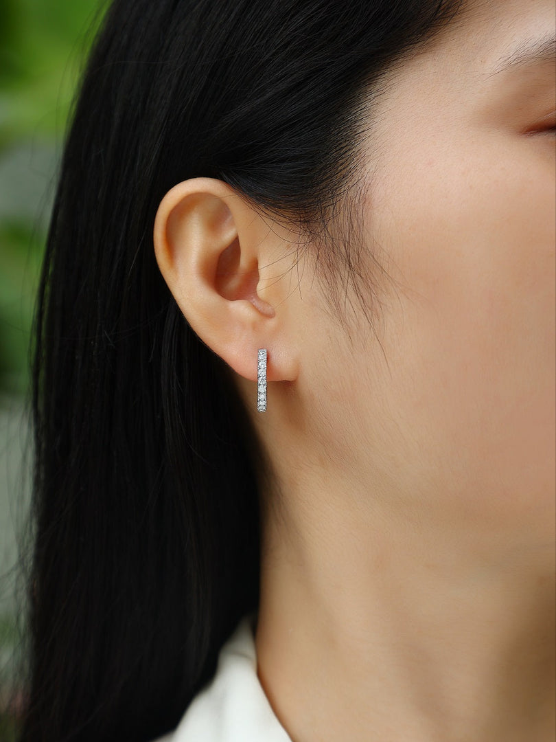 Close-up of a person wearing Pavé de Lumière Moissanite Hoop Earrings