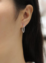 Load image into Gallery viewer, Close-up of an ear wearing Pavé de Luxe Moissanite Hoop Earrings
